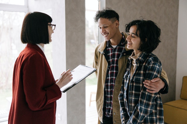 a couple talking to someone with a clipboard