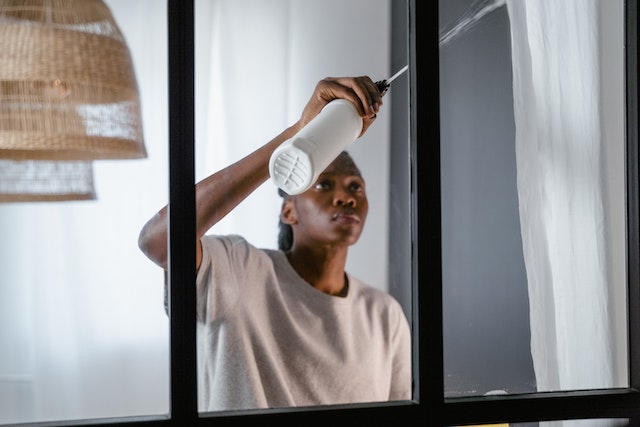 someone spraying a window with product